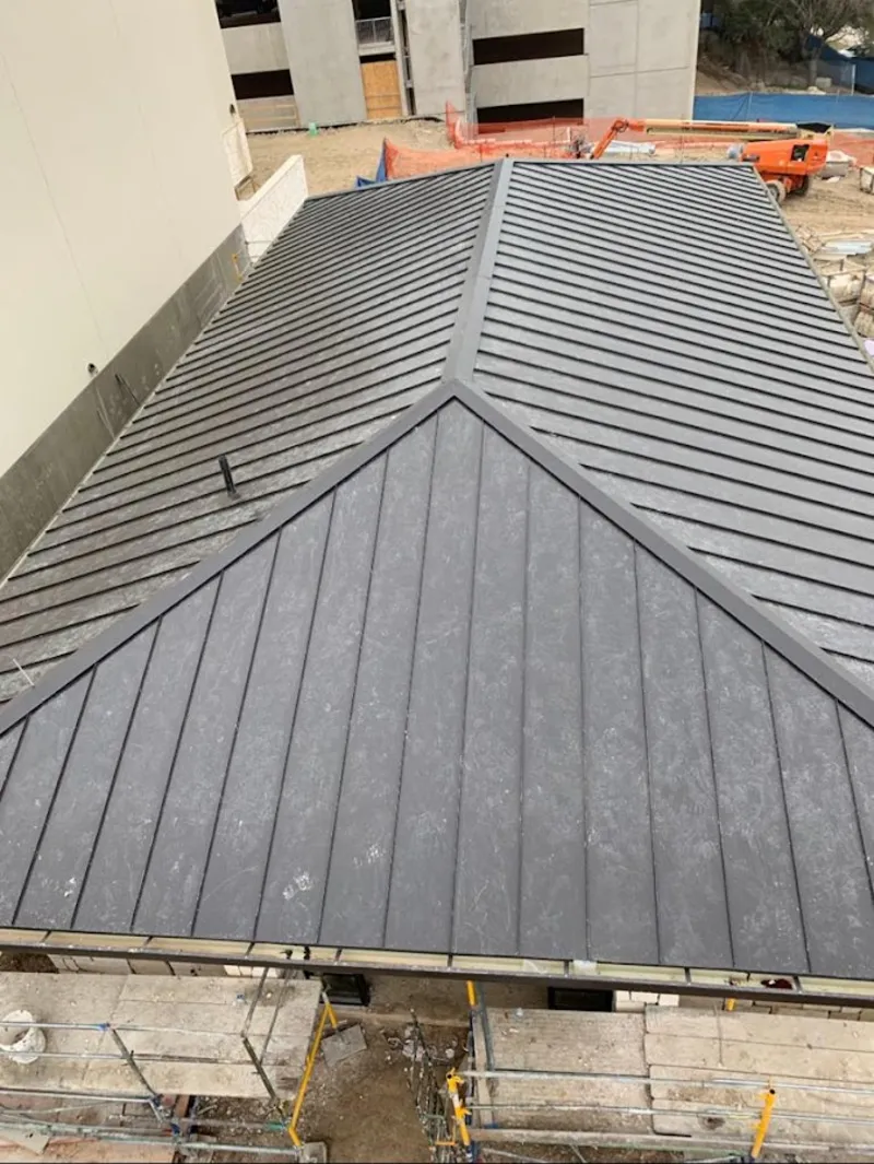 Commercial metal roof construction with crane equipment in Bull Mountain